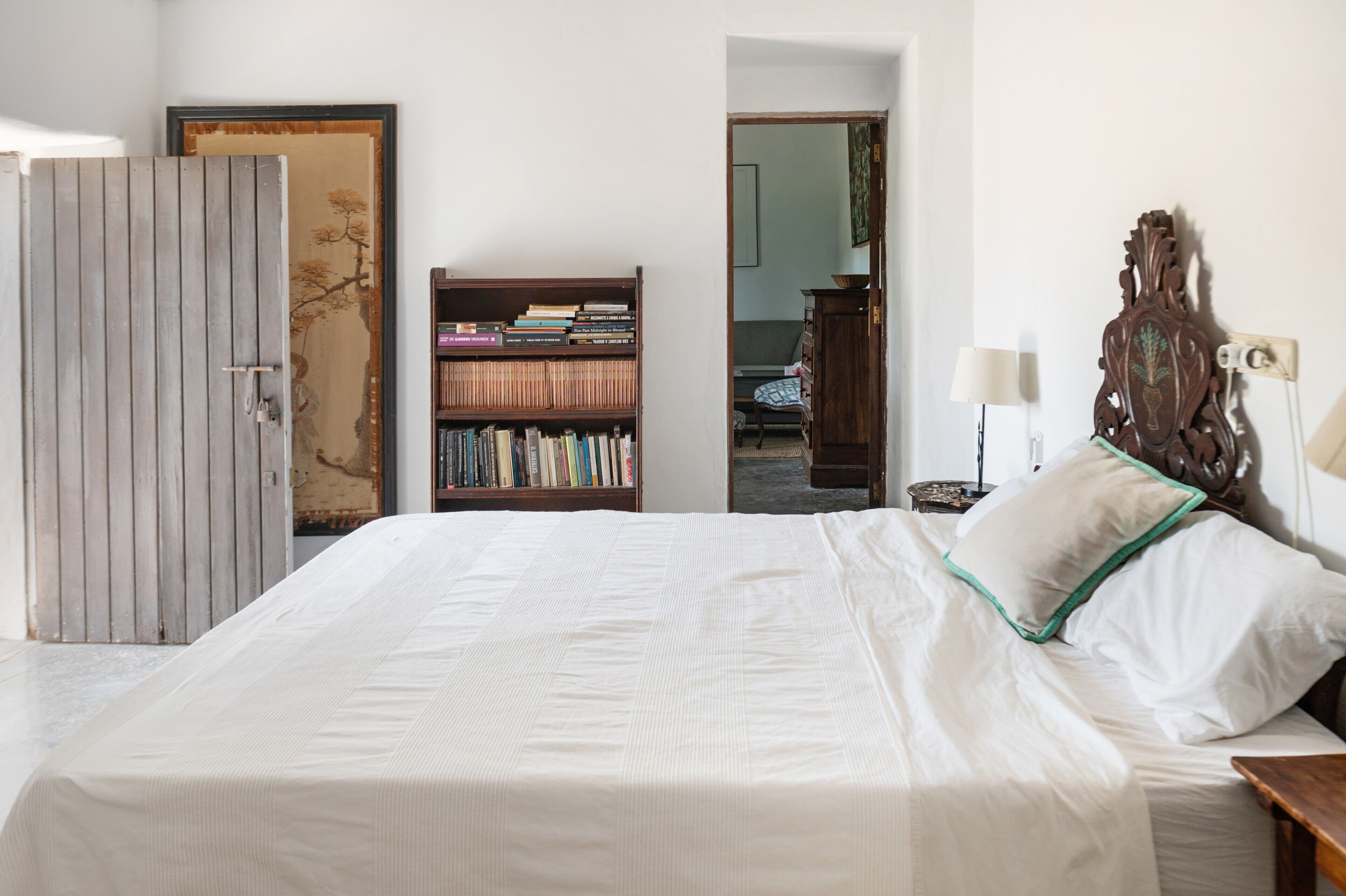 Une chambre à coucher avec un lit, une bibliothèque et une armoire.