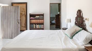 Un dormitorio con cama, estantería y armario.