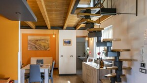 A modern kitchen with wooden beams, a dining area with a table and chairs, and a staircase with a unique design. - Wonderful private villa for 5 people with A/C, private pool, WIFI, TV, terrace and panoramic view (Sutri)