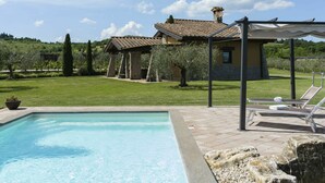 A swimming pool with a stone border, a grassy lawn, and a building with a tiled roof. - Wonderful private villa for 5 people with A/C, private pool, WIFI, TV, terrace and panoramic view (Sutri)