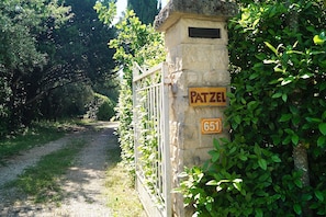 Un mur de pierre avec un portail portant l’inscription « Patzel » et le numéro « 651 ».