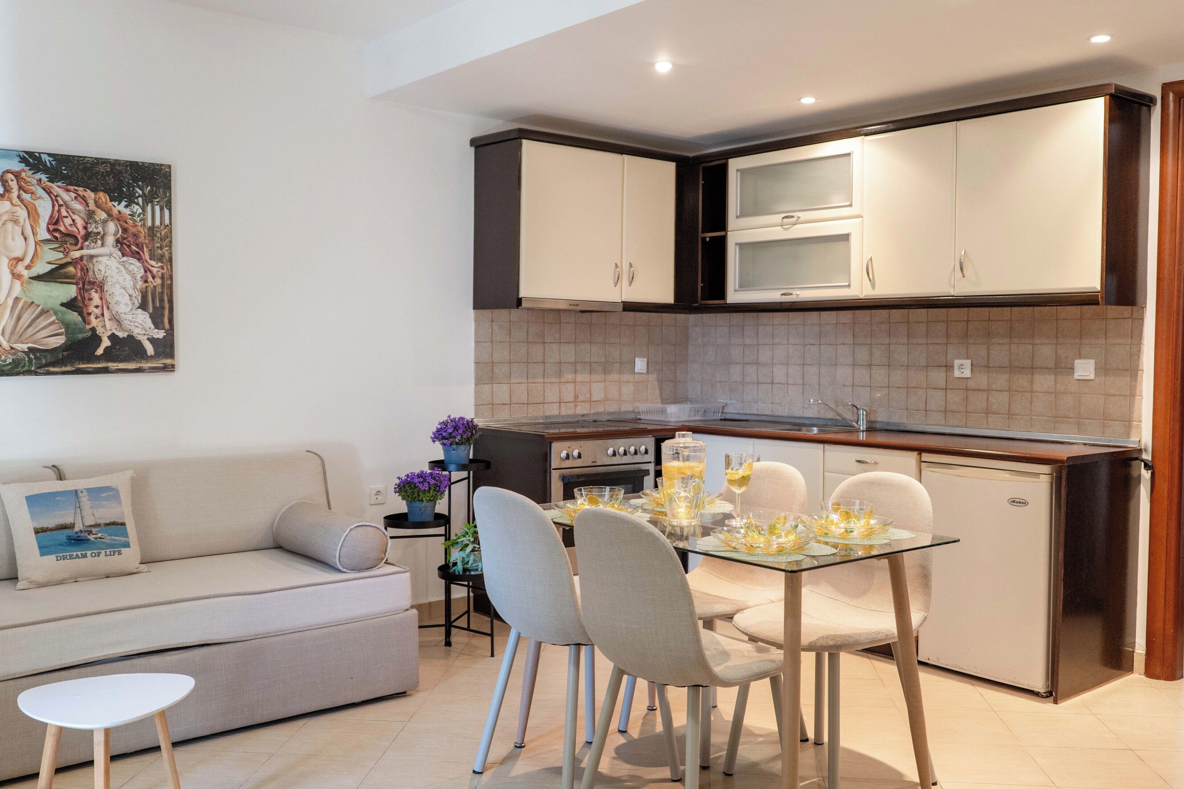 Une cuisine moderne avec un coin repas, un canapé et un tableau au mur.