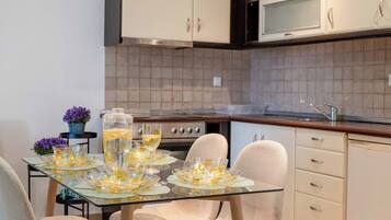 Une cuisine moderne avec des meubles blancs, une table à manger avec des chaises et un îlot de cuisine.