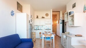 A compact living space with a kitchenette, a dining area, and a sofa.