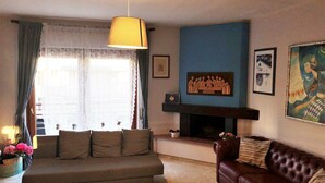 A living room with a sofa, a brown leather couch, a fireplace, and a painting on the wall. - Stella del Mare (Monopoli)