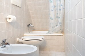 A bathroom with a toilet, sink, and bathtub. - Donna Lisa (Polignano a Mare)