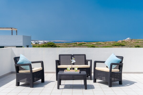 A terrace with wicker furniture and a view of the sea. - Villa with pool and sea view - Villa Rica (MENORCA)