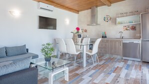 Una cocina moderna con comedor, un sofá y una planta en maceta.