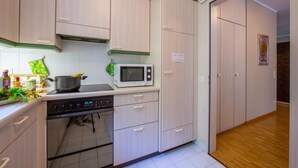Una cocina con microondas, estufa y alacenas.