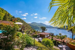 A hillside view of a lake with houses, a pool, and a gazebo. - Morcote Magic View (Morcote)
