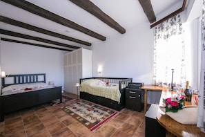 Une chambre à coucher avec un lit, une table de chevet, un bureau et une fenêtre avec des rideaux.