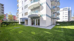A modern apartment building with balconies, a well-maintained lawn, and a clear sky. - Prestige du Lac 4 (Lugano)