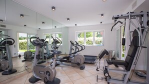 A gym with various exercise machines, large windows, and a tiled floor. - Prestige du Lac 4 (Lugano)