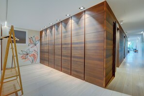 Un interior moderno con un armario de madera, un caballete de madera y una pared con un diseño floral.