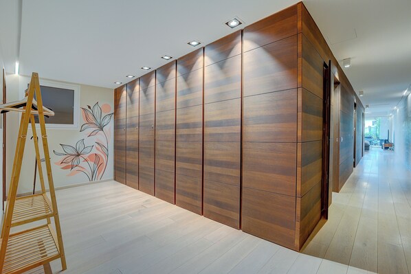 Un interior moderno con un armario de madera, un caballete de madera y una pared con un diseño floral.