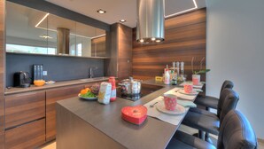 Una cocina moderna con una isla central, paneles de madera y electrodomésticos contemporáneos.