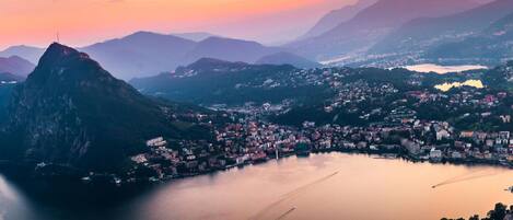 A coastal town with a prominent mountain, calm water, and a marina.