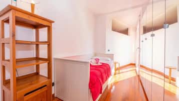 A bedroom with a bed, a wooden cabinet, and a wardrobe.
