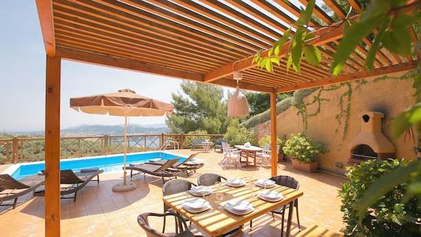 A covered outdoor area with a pool, lounge chairs, and a table set for dining. - Europa,2br,2bth Villa With Private Pool And Stunning Sea Views (Skiathos)