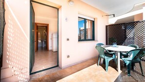 Una habitación con una mesa de comedor, sillas, una ventana y una puerta que da a otra estancia.