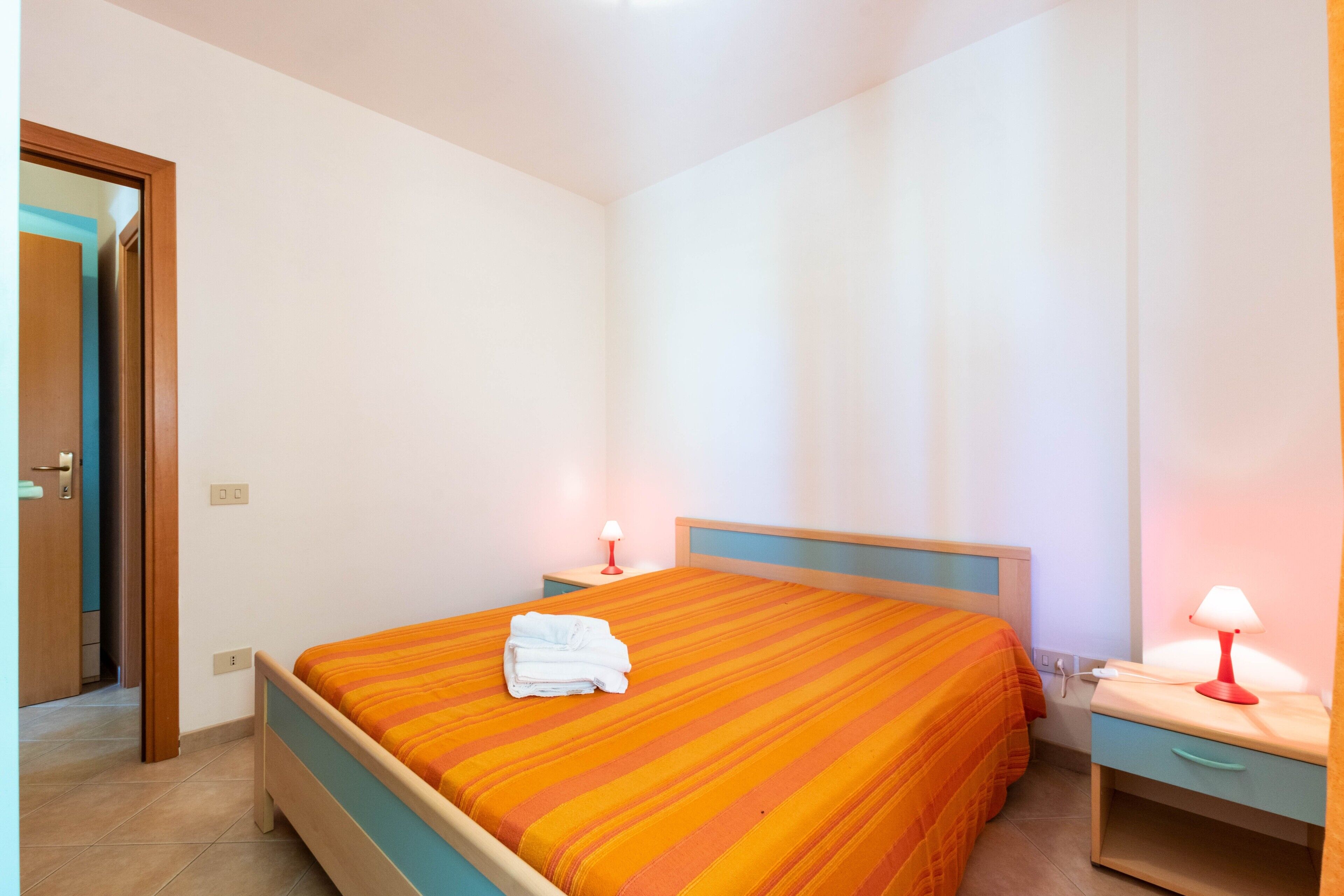 Ein Hotelzimmer mit Bett, Nachttischen und einer Tür.