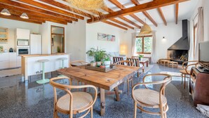 A spacious kitchen with wooden beams, a dining area with a large wooden table, and a fireplace. - Holiday Home "Sa Teulera de Sencelles" with Pool & Wi-Fi (Sencelles)
