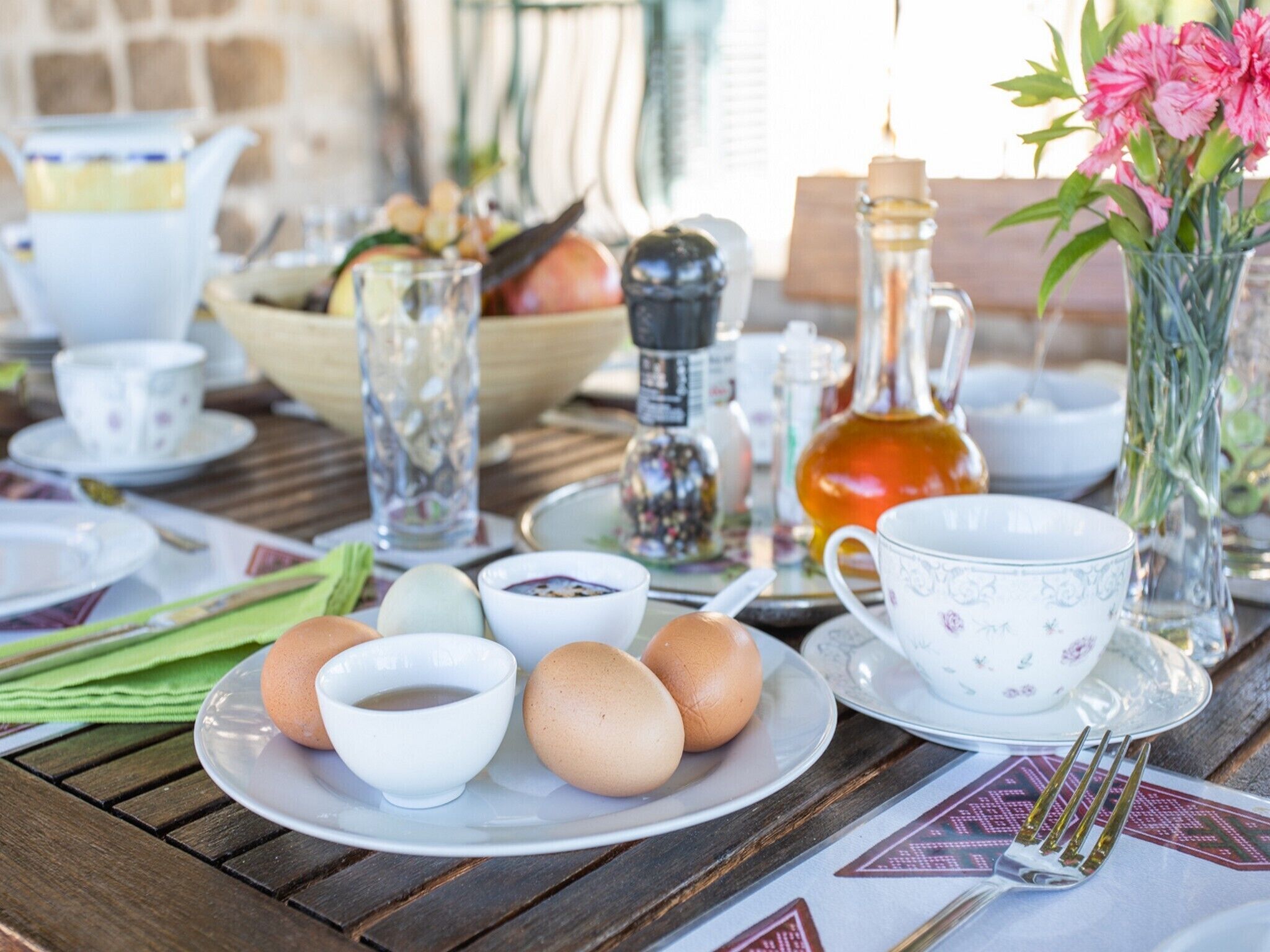 Ein Frühstückstisch mit Eiern, Tassen und einem Teekessel.