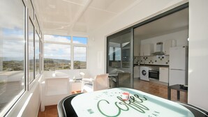 A modern kitchen with a view, a dining area with a table, and a large window. - Close to Hiking and Beach with Beautiful Winter Garden - Apartment Ye (Haria)