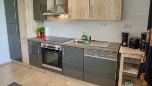 Een moderne keuken met roestvrijstalen apparatuur, houten kasten en een inbouwvaatwasser.