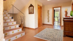 A staircase with star-patterned tiles, a wooden door, and a patterned rug. - Beautiful Country House "Can Cancus" in Nature with Rooftop Terrace, Garden & Wi-Fi (Capdepera)