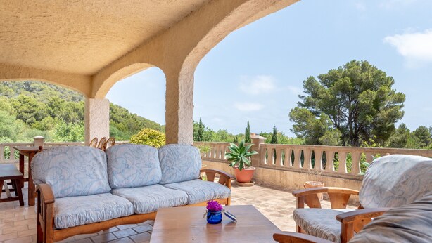 An outdoor patio with a wooden sofa, chairs, a table, and potted plants. - Beautiful Country House "Can Cancus" in Nature with Rooftop Terrace, Garden & Wi-Fi (Capdepera)