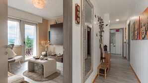 En modern inredning med ett matområde, en hall med konstverk och en utsikt genom ett fönster.