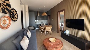 Una sala de estar moderna con sofá, mesa de centro y comedor con sillas.