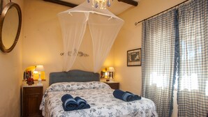 A bedroom with a bed, bedside lamps, a nightstand, a mirror, and a window with curtains. - Villa Stella Close to the Beach with Wi-Fi, A/C, Garden;Parking (Santa Margherita di Pula)