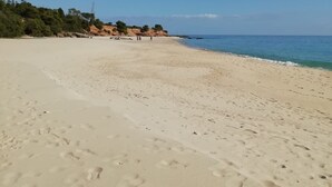 A wide sandy beach with footprints, a clear blue sky, and a distant shoreline with sparse vegetation. - Villa Stella Close to the Beach with Wi-Fi, A/C, Garden;Parking (Santa Margherita di Pula)