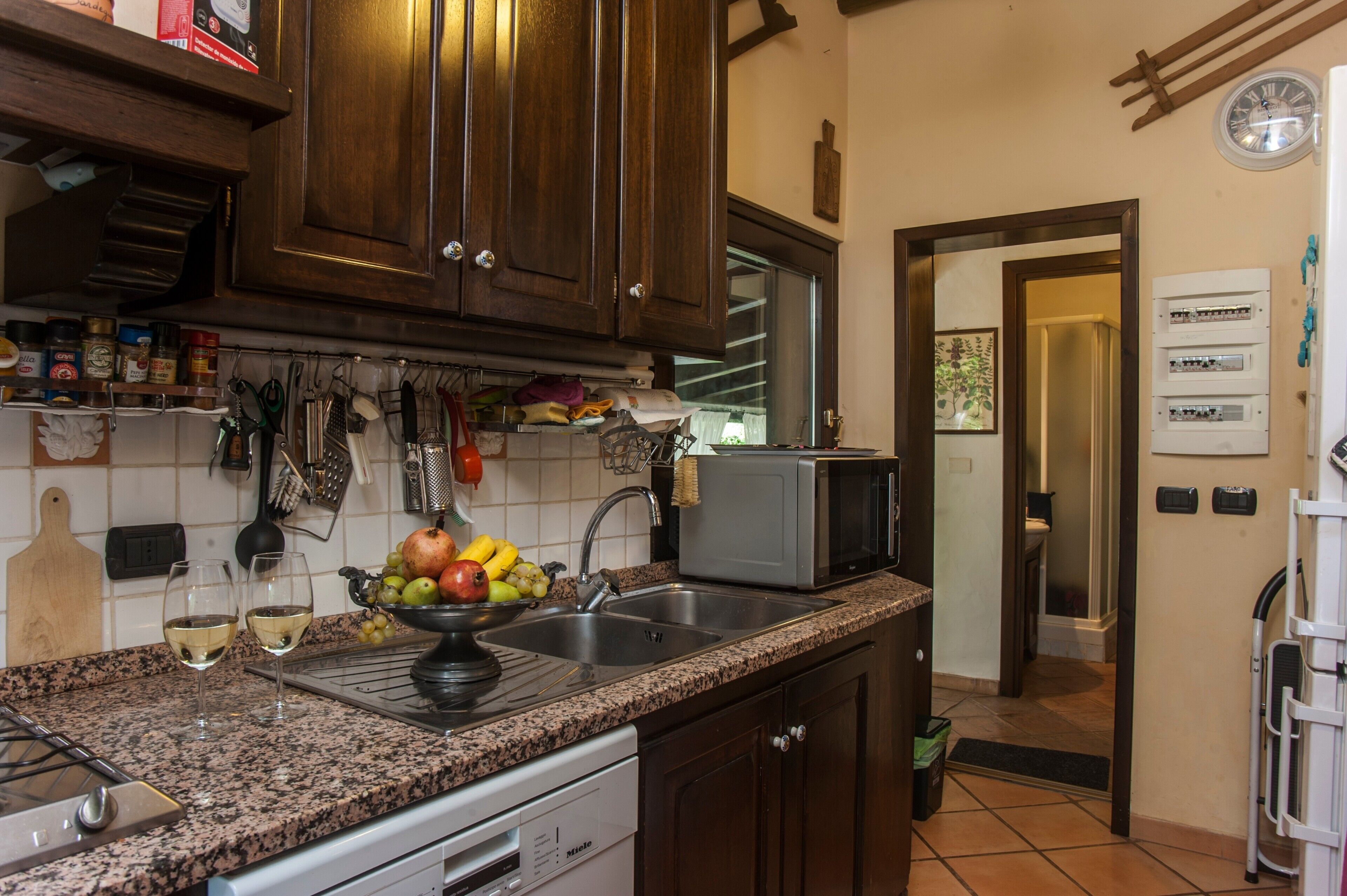 A kitchen with granite countertops, a microwave, a sink, and wooden cabinets.