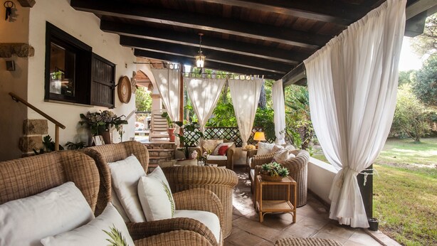A covered outdoor seating area with wicker furniture, a wooden ceiling, and a view of a garden. - Villa Stella Close to the Beach with Wi-Fi, A/C, Garden;Parking (Santa Margherita di Pula)