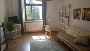 Apartamento, vista para o jardim | Sala de estar | TV