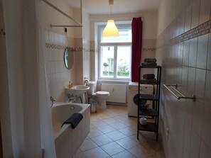 Ein Badezimmer mit einer Badewanne, Waschbecken, Toilette und einem Fenster mit Blick.