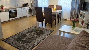 Een functionele leefruimte met keuken, eethoek en zithoek.