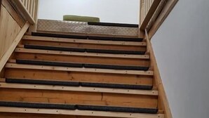 A wooden staircase with a handrail on both sides, leading to a room with a white wall and a skylight. - Dresdner-Tag Hermann (Dresden)