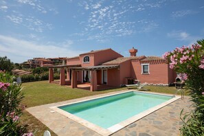 A swimming pool, a covered patio, and a building with a red facade. - Mediterranean Villa with a lot of privacy - Villa Allegra (Punta de Su Turrione)