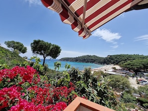 Panorama sulla costa con spiaggia, imbarcazioni e cielo sereno.