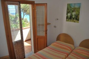 Una camera da letto con un letto, una porta che dà su uno spazio esterno e un quadro appeso al muro.