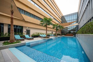 Una piscina al aire libre, sillones reclinables de piscina