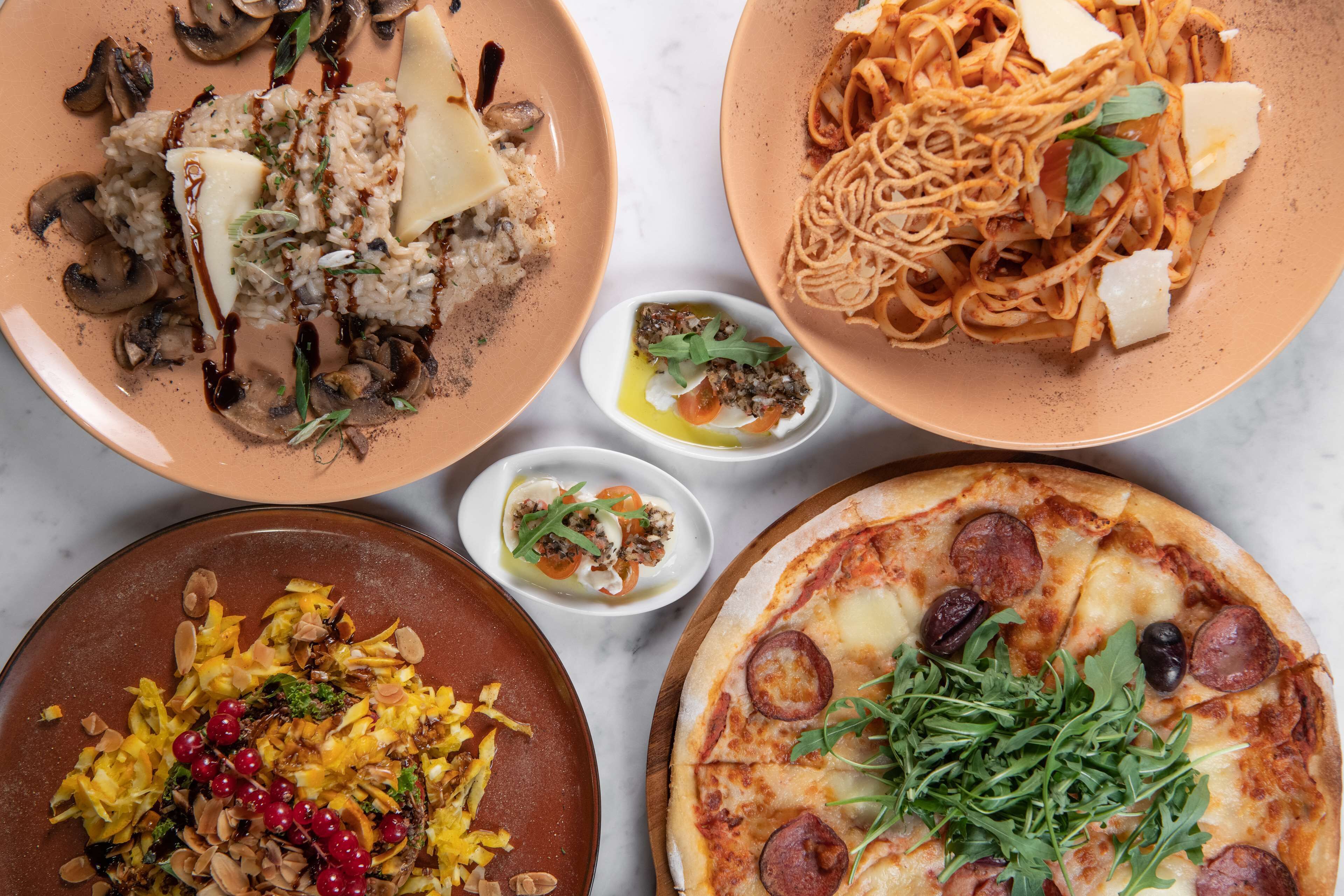 A variety of dishes including pasta, pizza, and a salad.