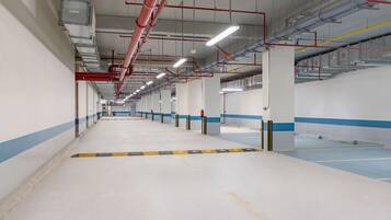 A spacious, well-lit indoor area with a long corridor lined with columns and fire safety equipment.