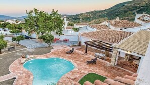 Una propiedad residencial con piscina, mobiliario de exterior y vistas del paisaje circundante.