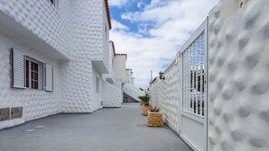 A narrow street with white buildings, a clear sky, and potted plants. - Lovely Apartment Close to the Beach with Terrace & Wi-Fi (Costa Calma, Fuerteventura)