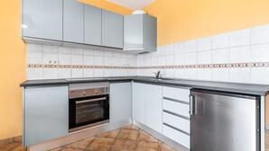 A kitchen with white cabinets, a stainless steel refrigerator, and a tiled backsplash. - Lovely Apartment Close to the Beach with Terrace & Wi-Fi (Costa Calma, Fuerteventura)